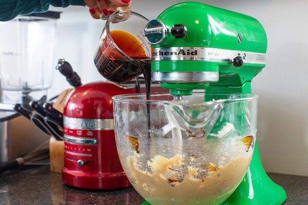 Pouring Molasses into the bowl of a stand mixer.