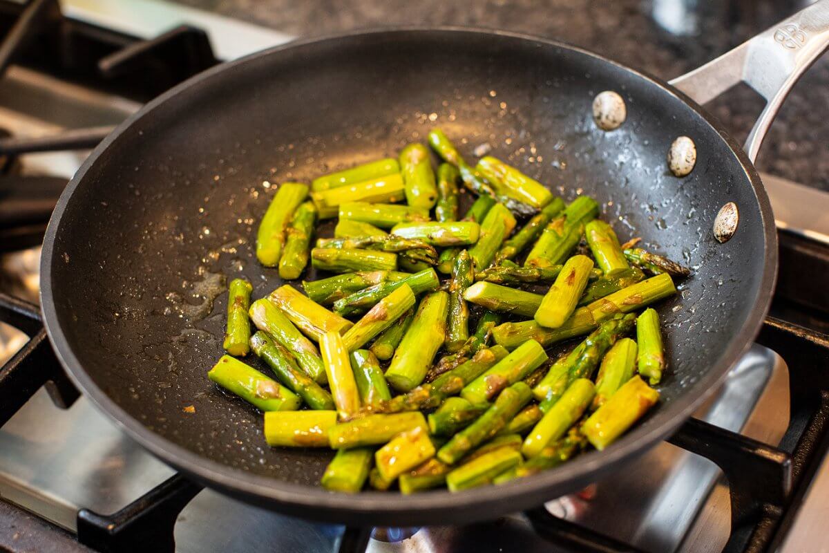 Sautéing asparagus in skillet.