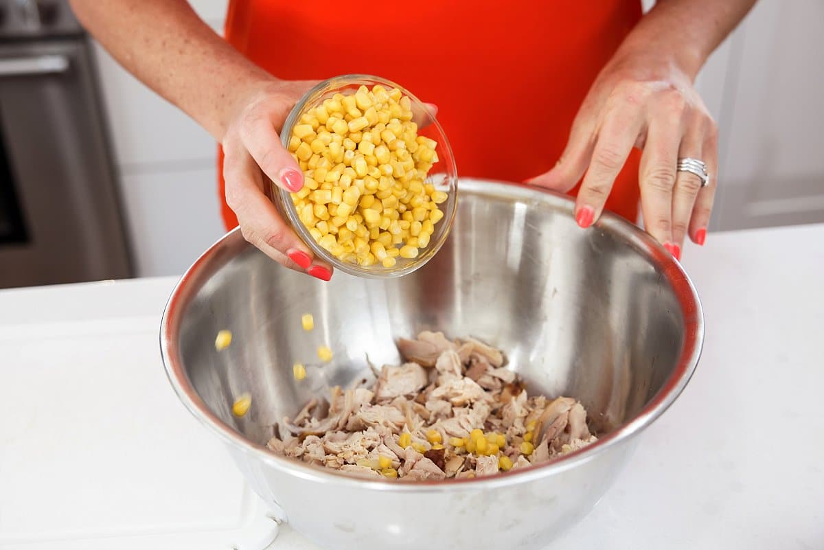 adding corn to bowl