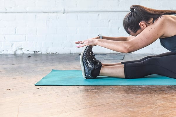Liz Della Croce stretching on a yoga mat.