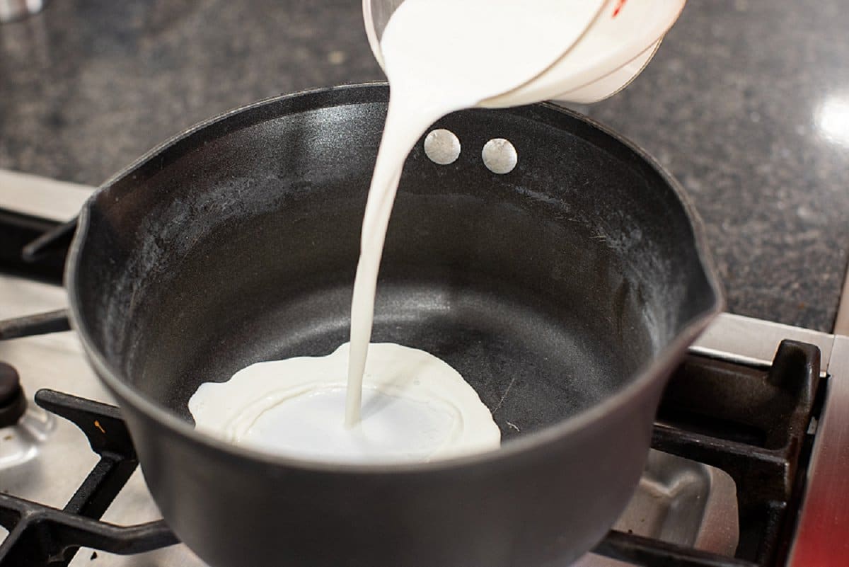 Pouring milk into pot.
