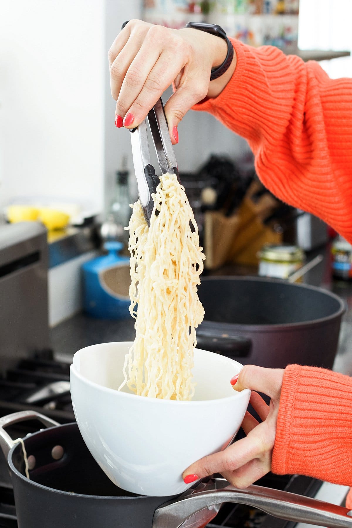 adding noodles to bowl