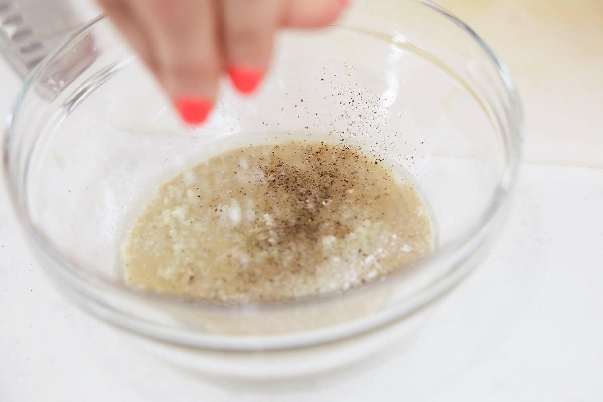 adding seasoning to tahini sauce