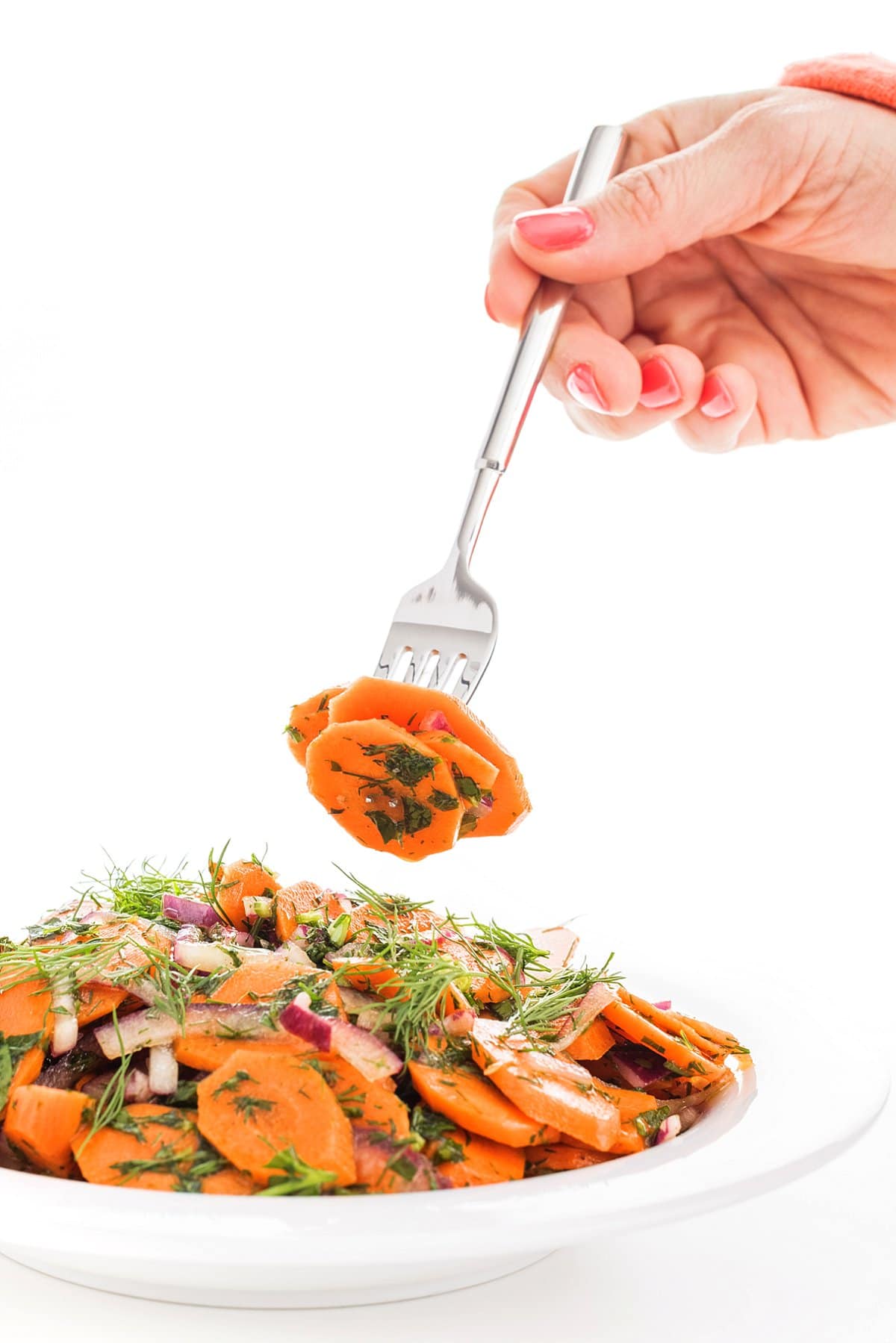 bowl and fork of carrot herb salad with dill and red onion
