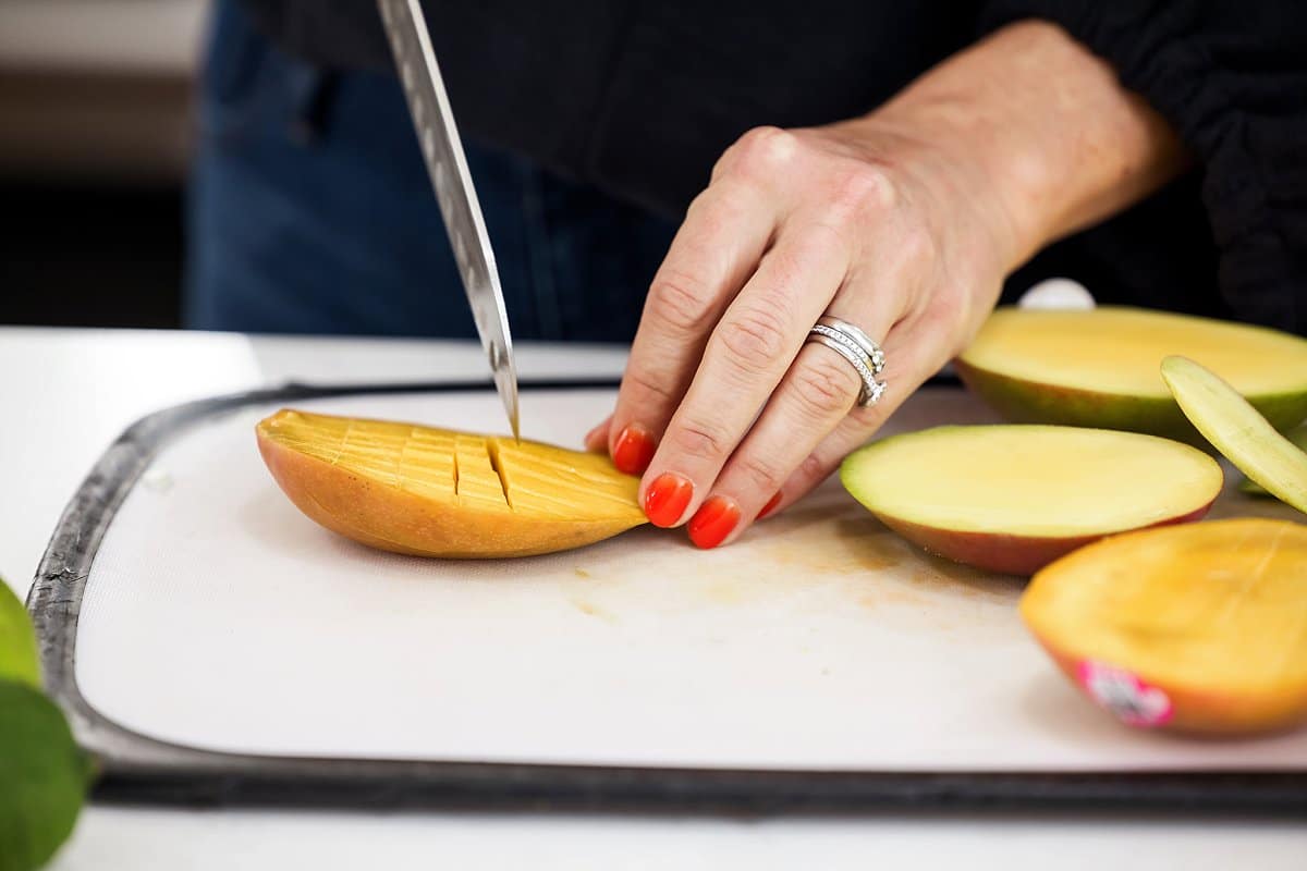 Liz scoring mango with a sharp knife.
