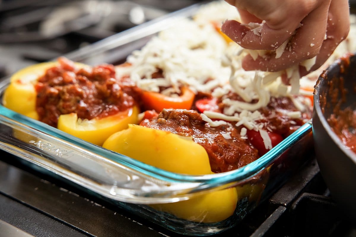 covering stuffed peppers with cheese