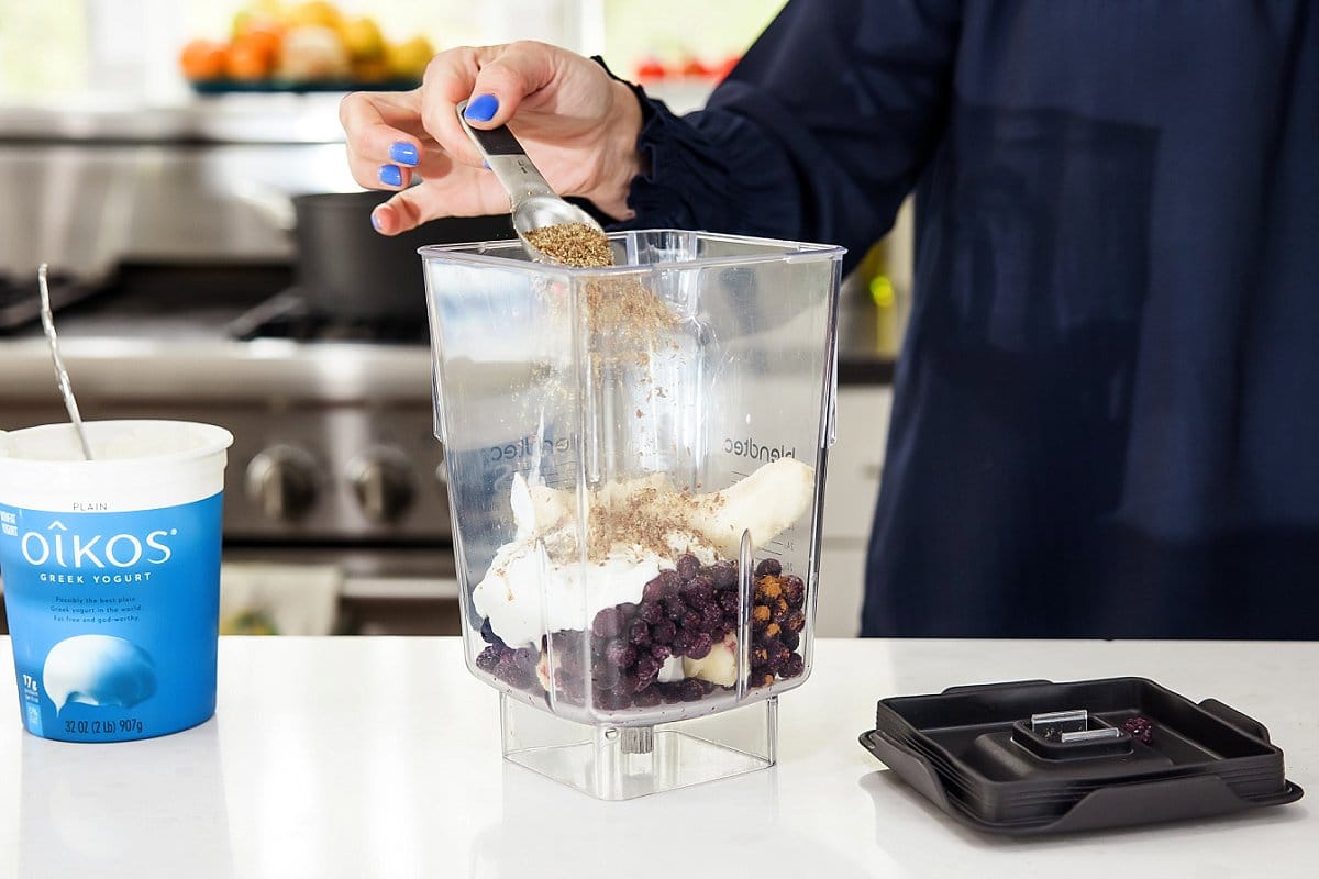 adding an ingredient into a blender