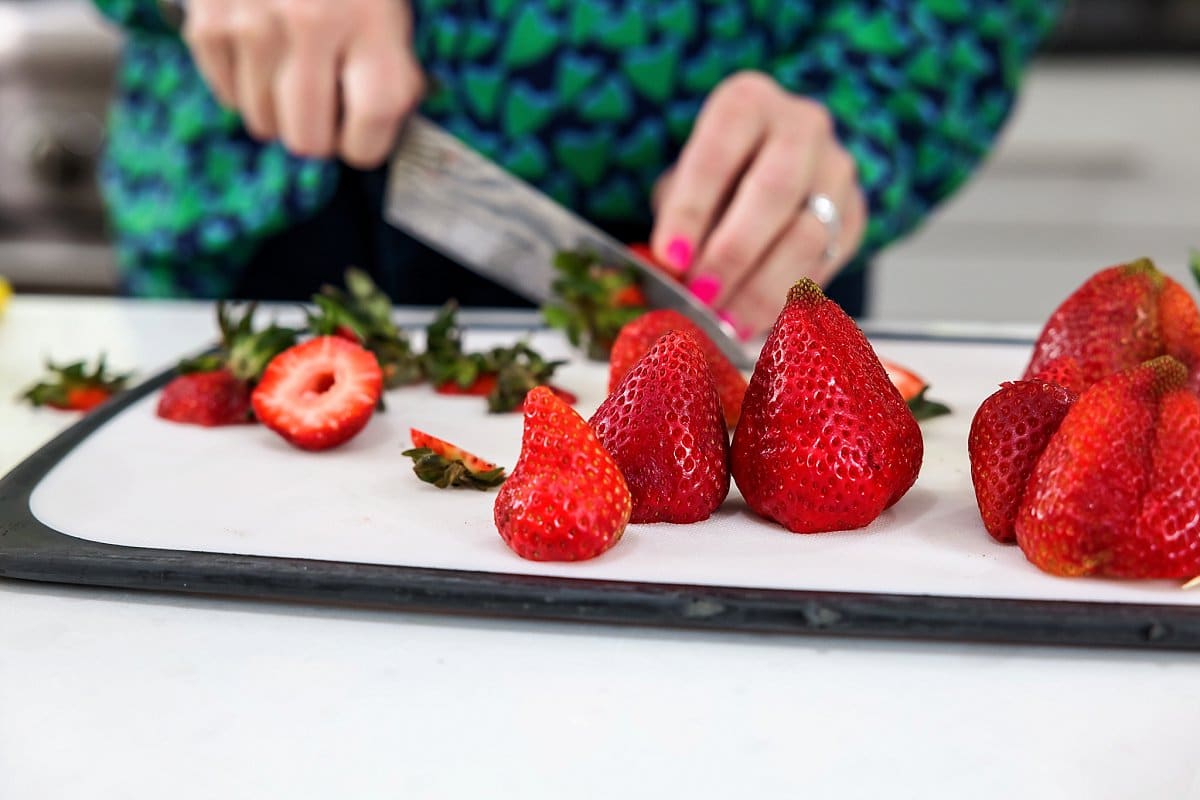 cutting strawberries on a cutting board
