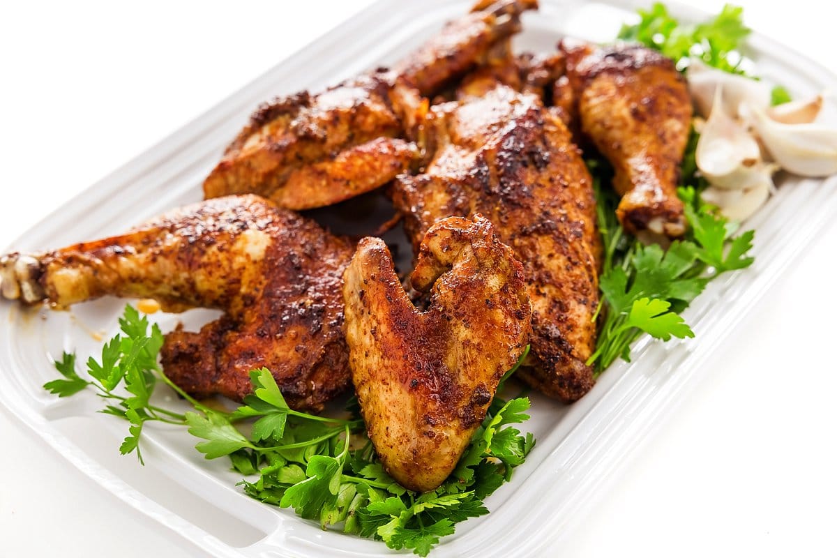 Roasted chicken pieces up close on a serving platter.