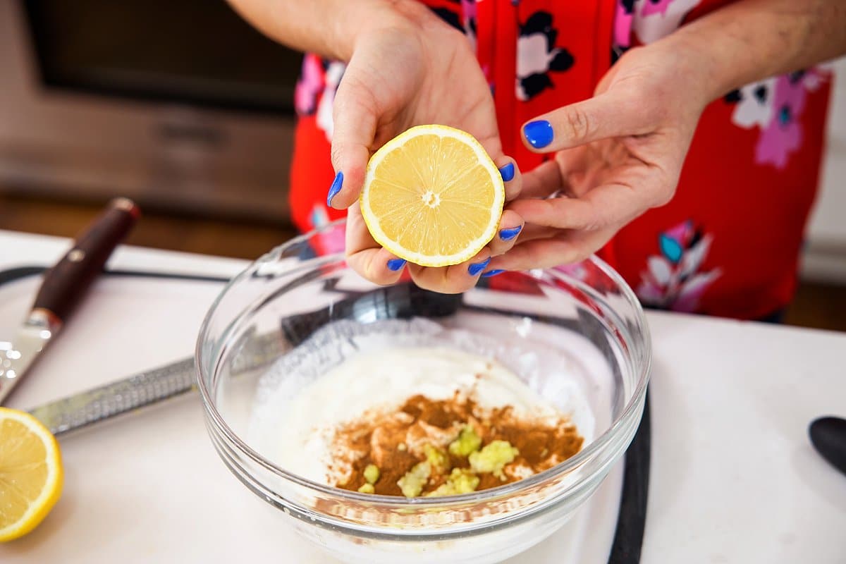 adding lemon to grilled chicken in a bowl