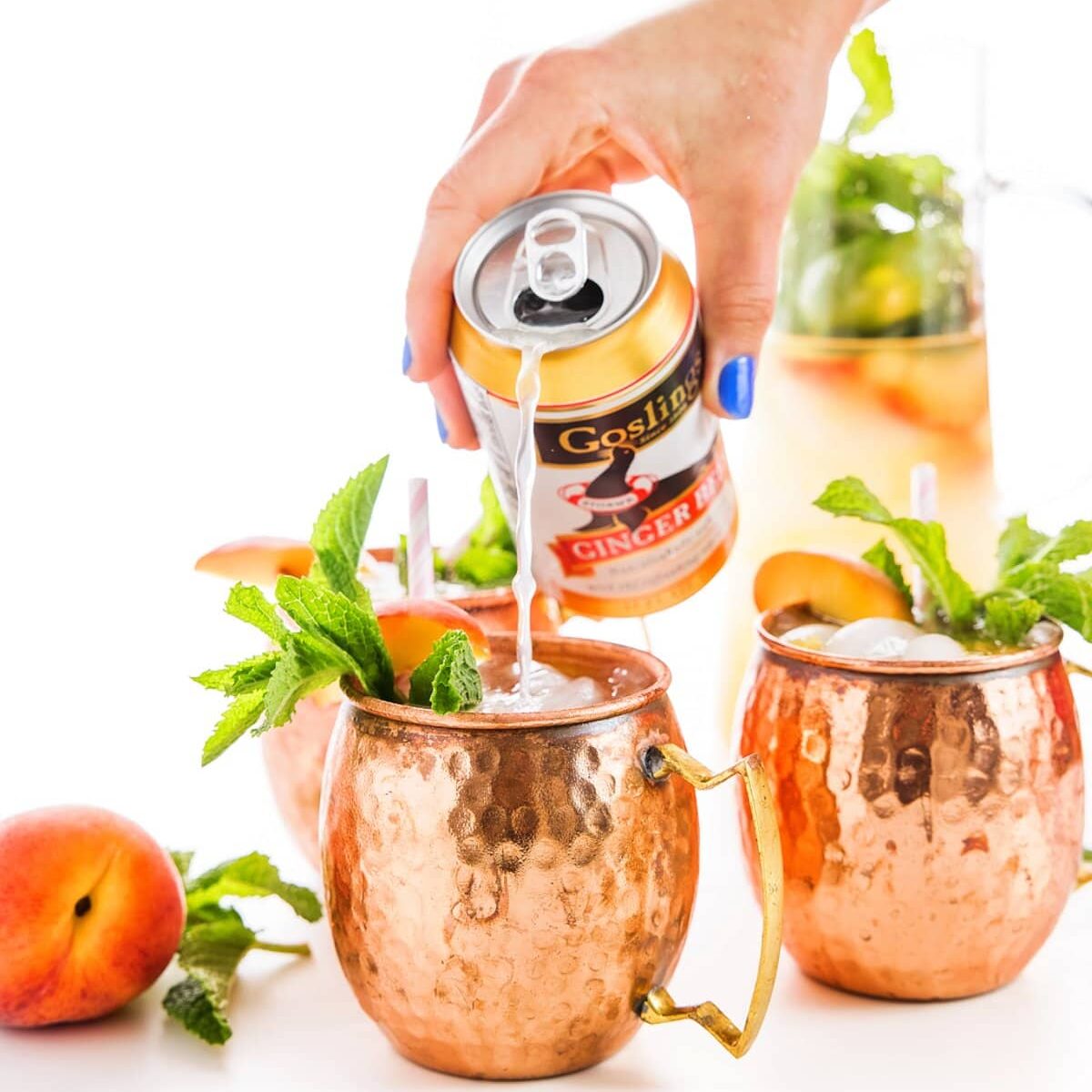 pour ginger beer into peach moscow mules