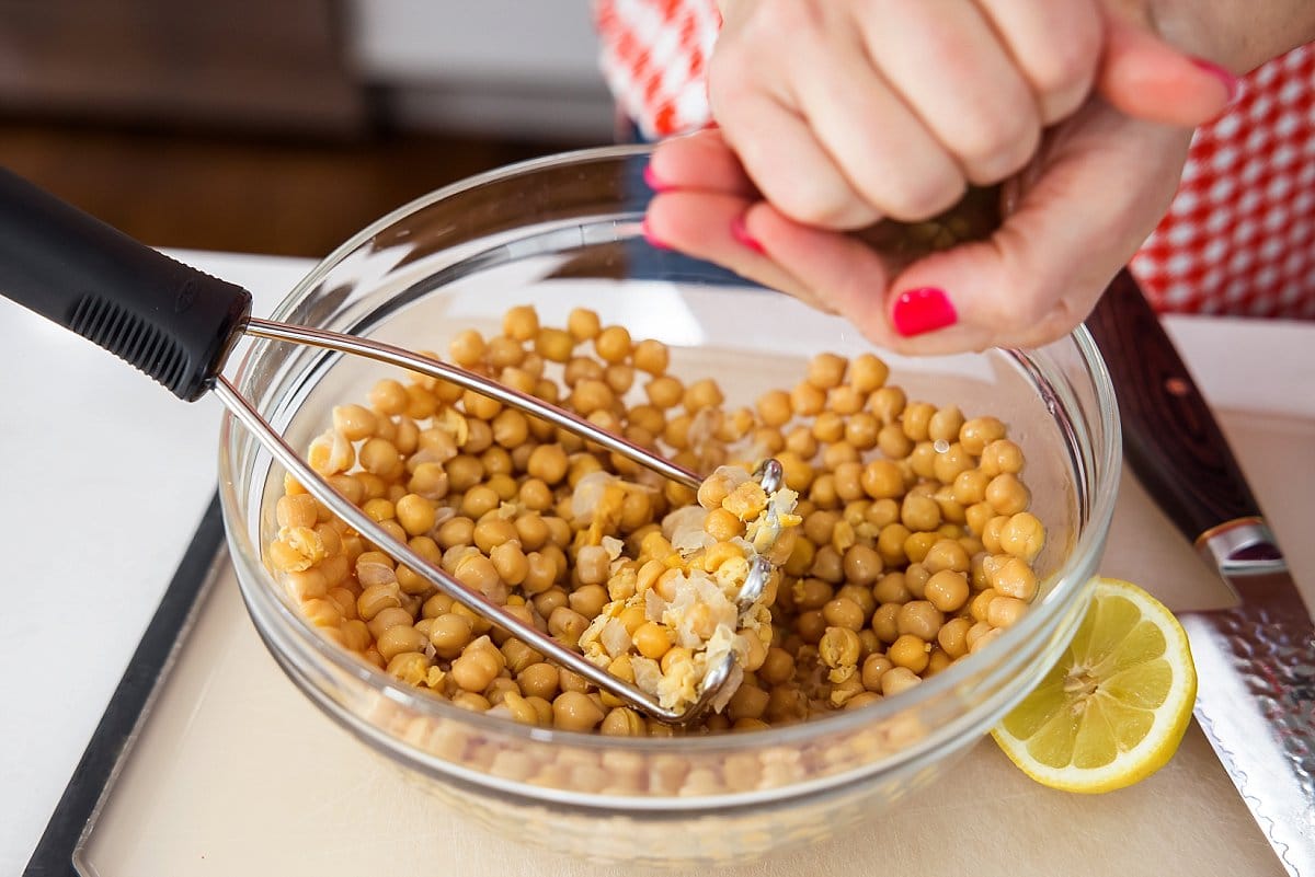 Squeezing lemon juice onto chickpeas