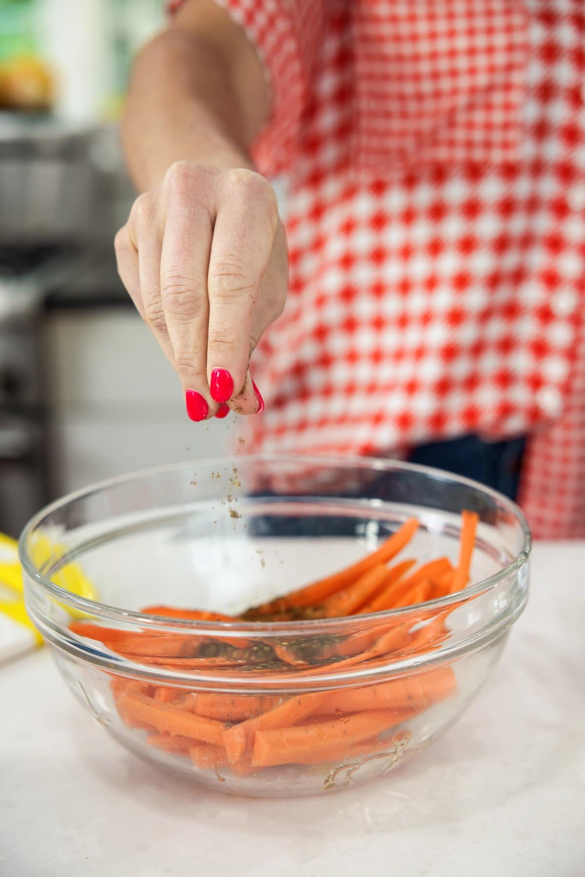 Liz sprinkling za’atar on carrots.