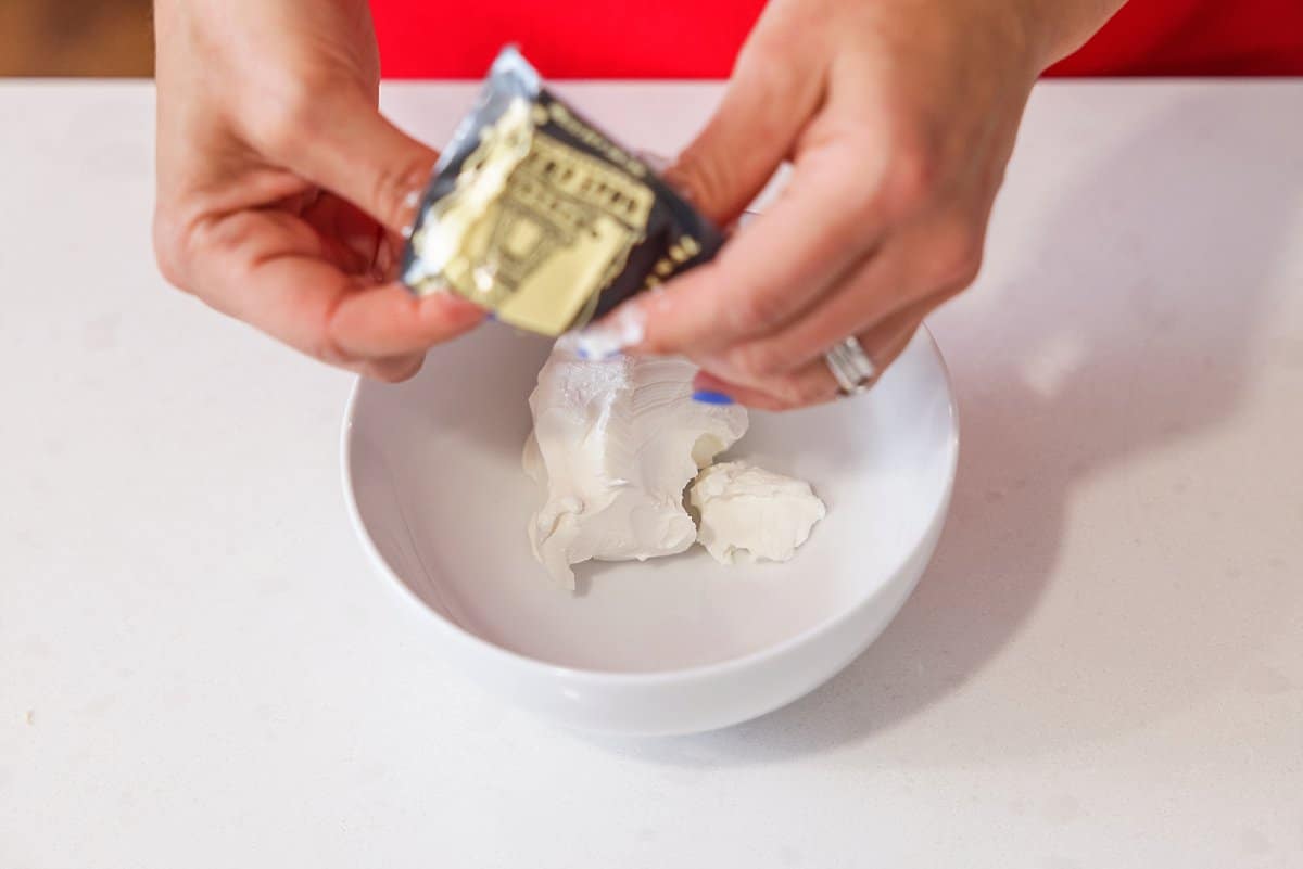 Adding goat cheese to a empty bowl