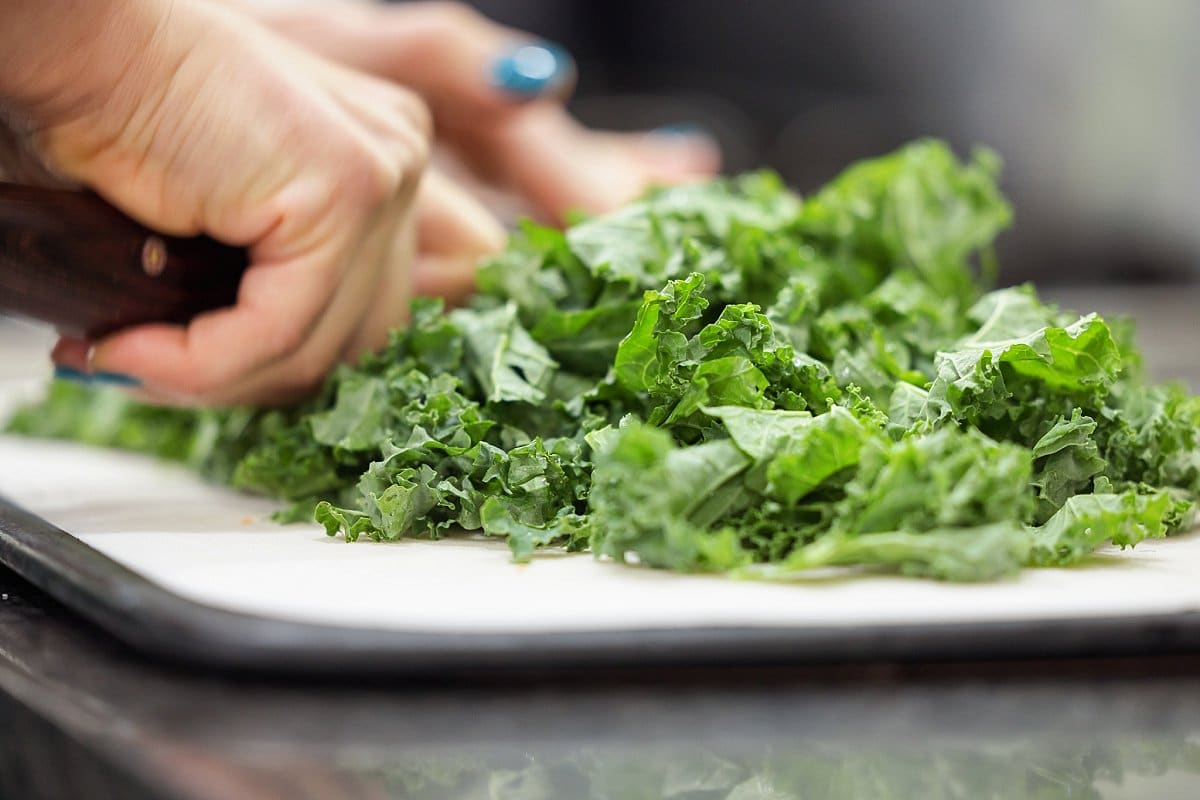 A close up of a person cutting kale