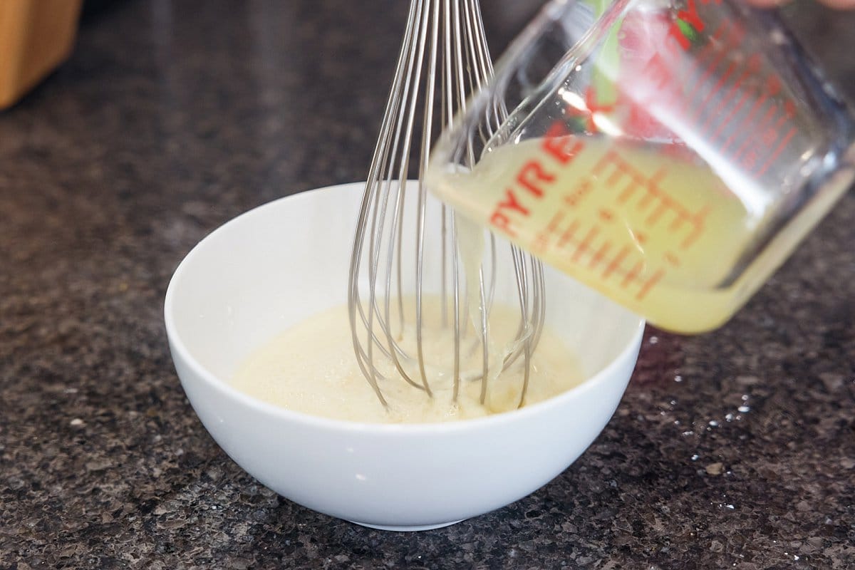Whisking in lemon juice in a bowl