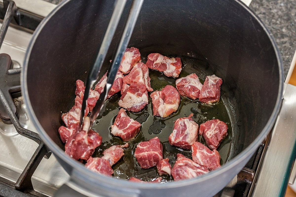 Cooking pork shoulder in the bottom of a pot.