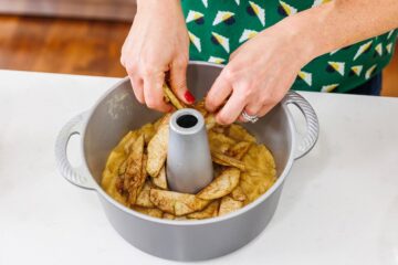 A person adding ingredients to a cake pan