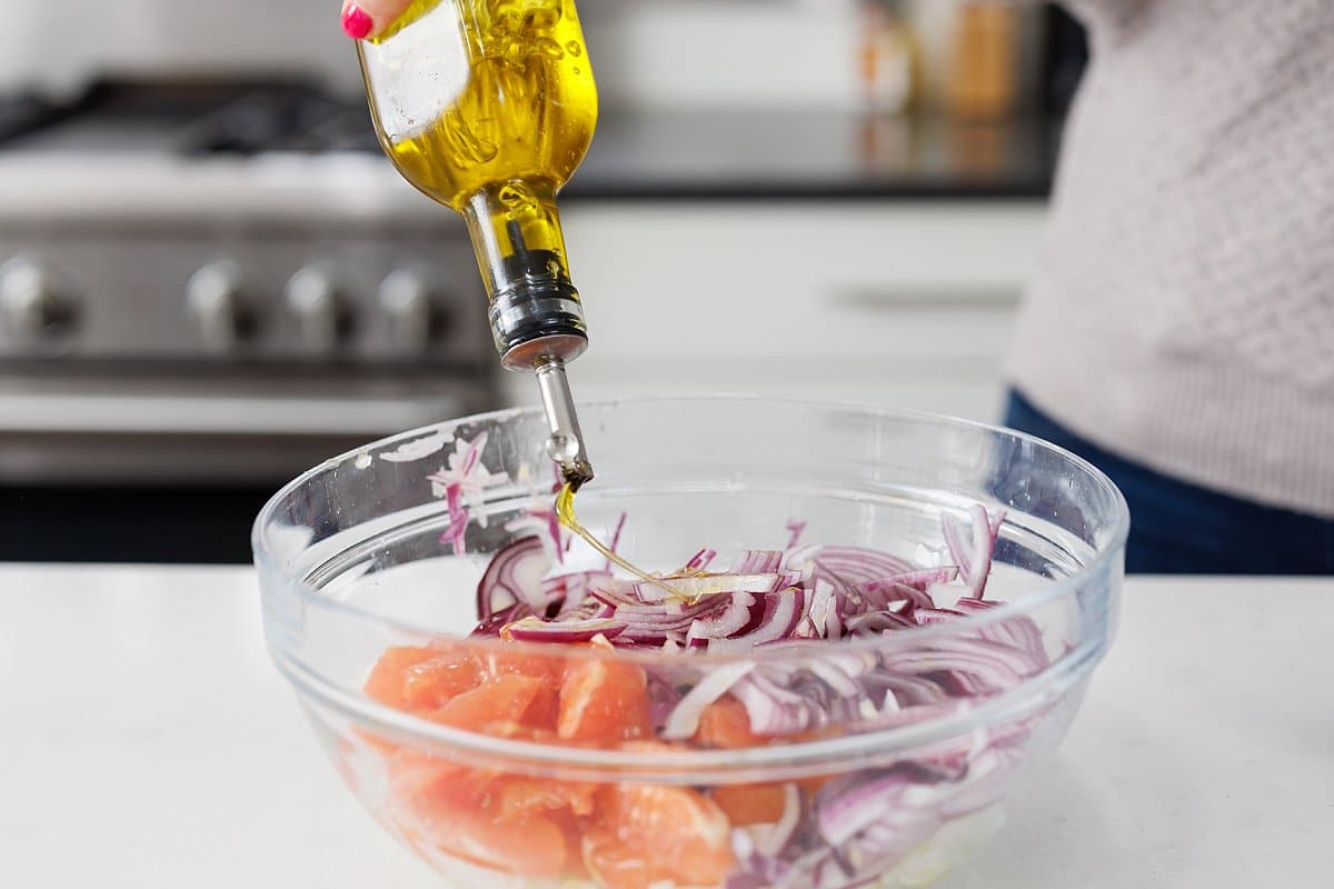 Drizzling salad with olive oil.