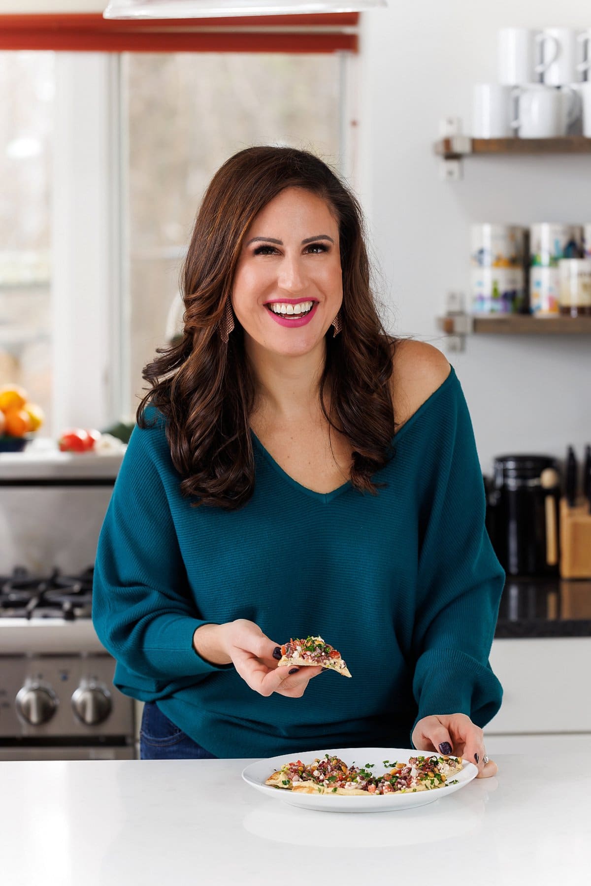 Liz eating hummus pizza with greek tapenade.