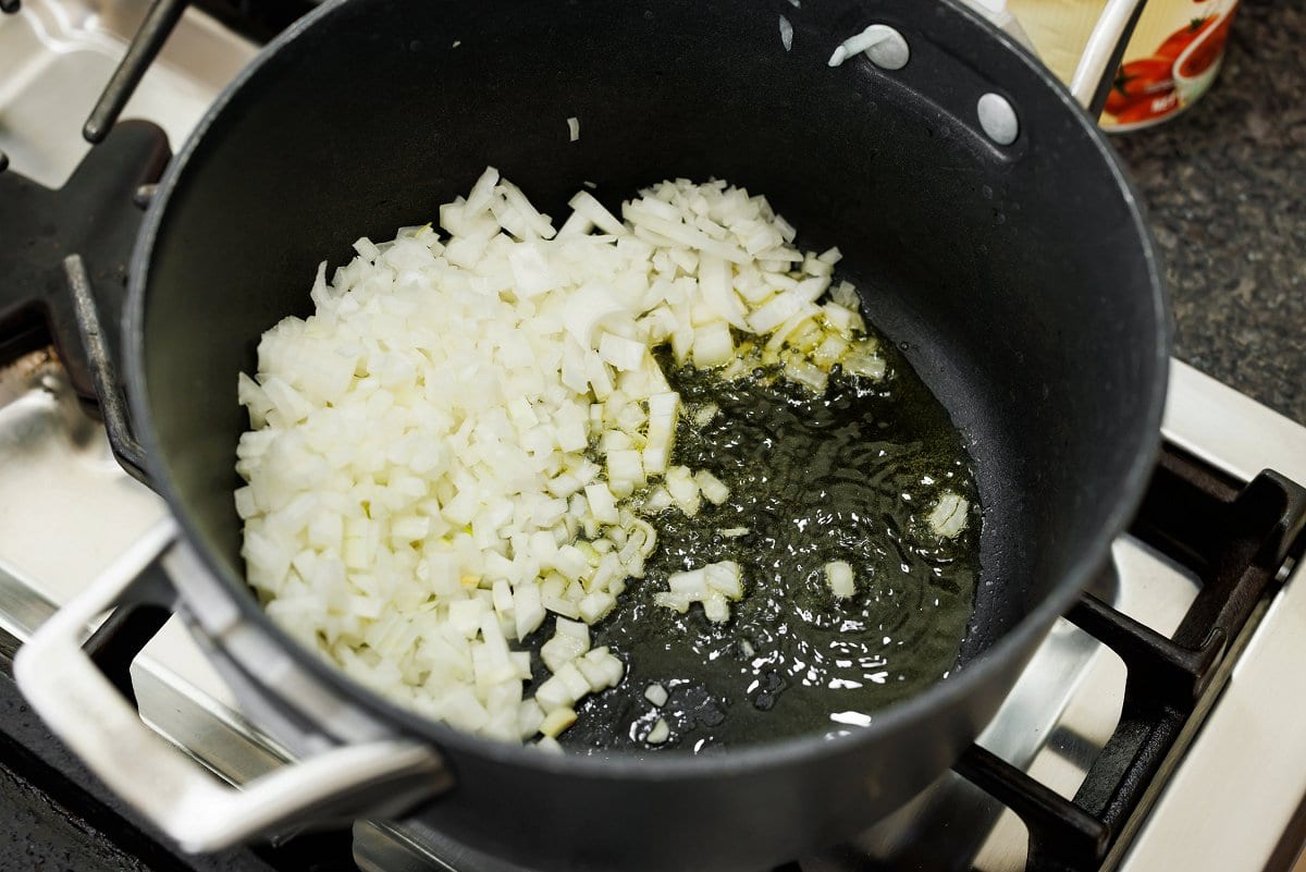 Sautéing onions in ghee in a pot.