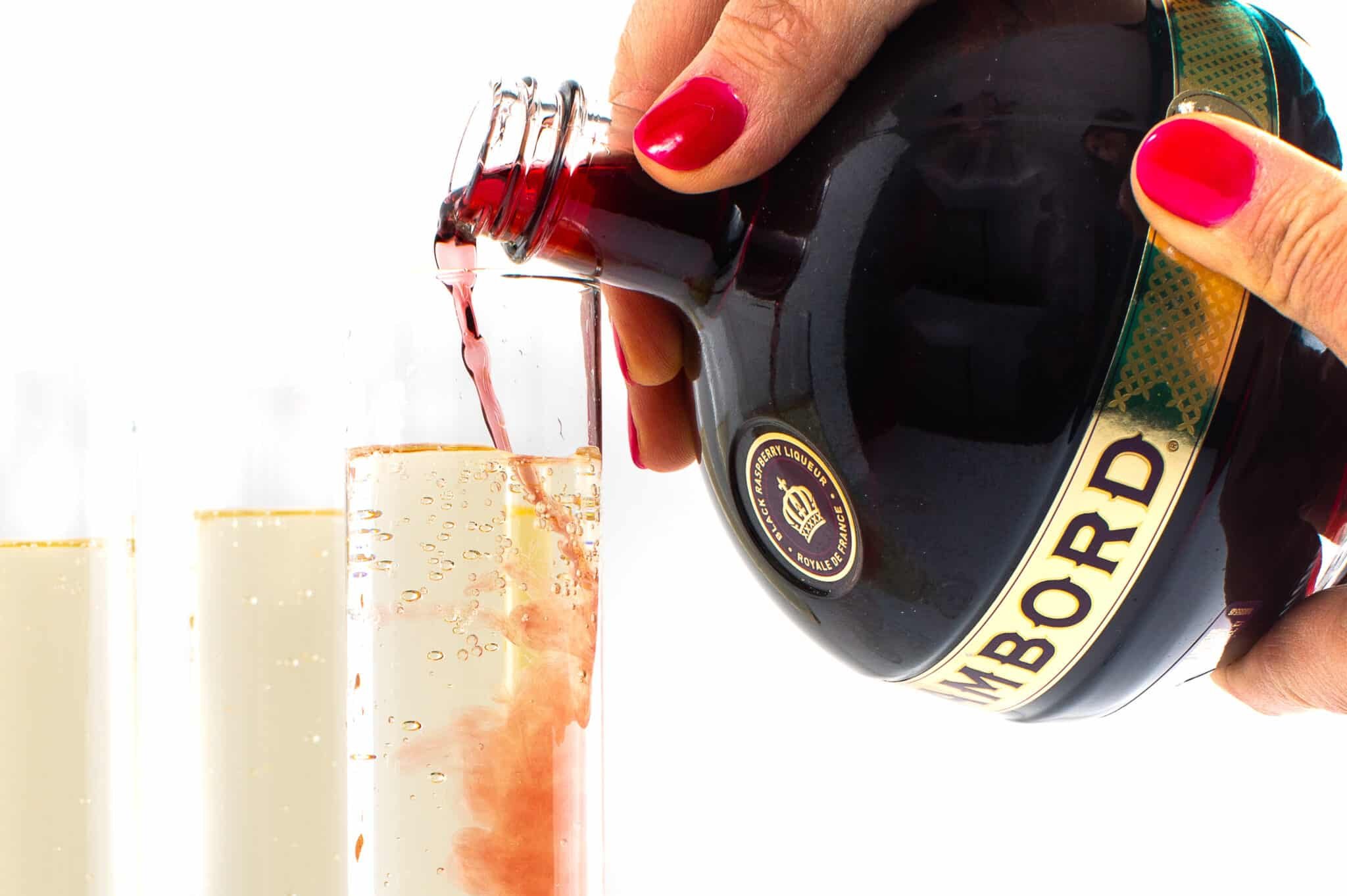 Pouring kir royale- festive cocktail.