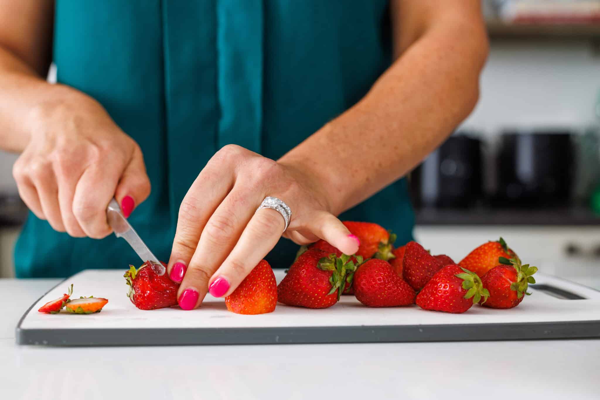 Liz destemming strawberries for how to freeze berries.