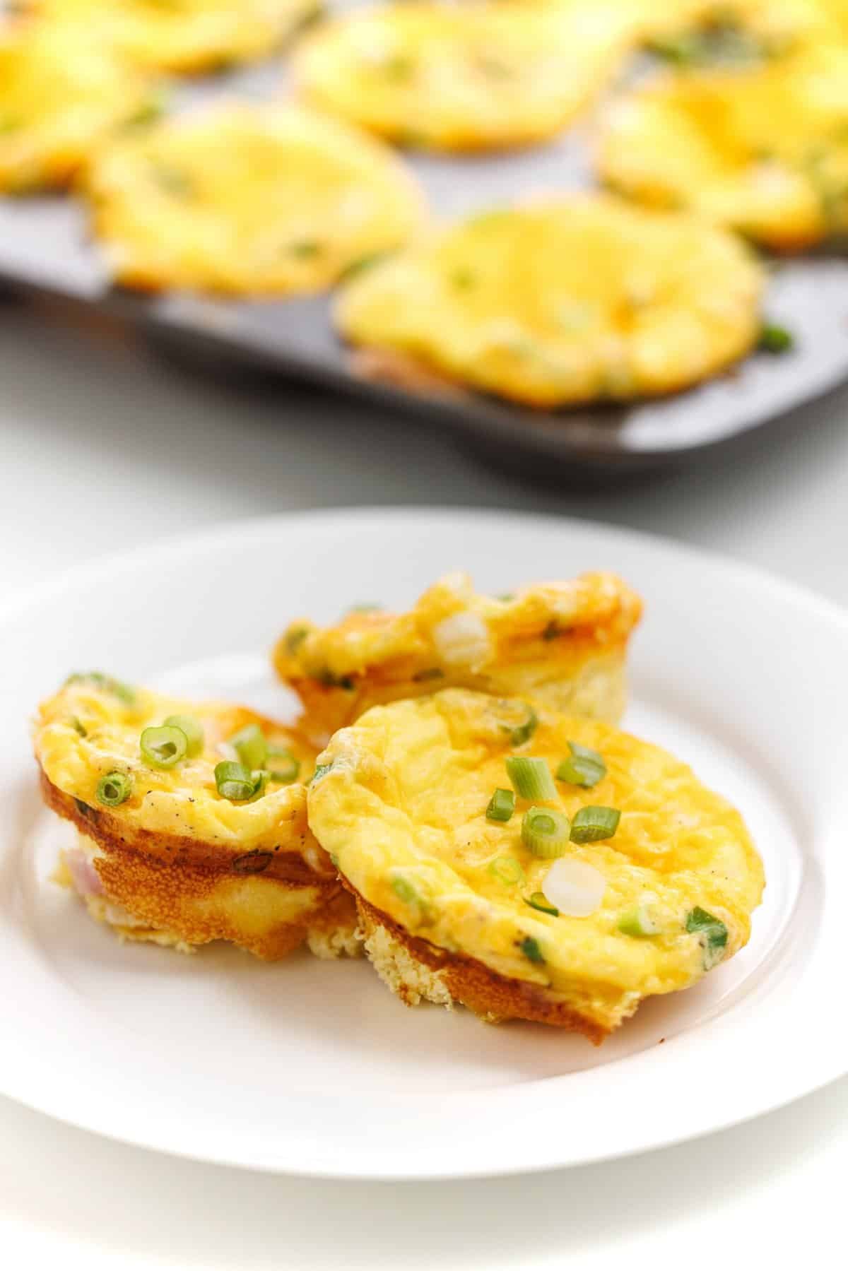 Ham and cheese baked egg cups garnished with scallions.