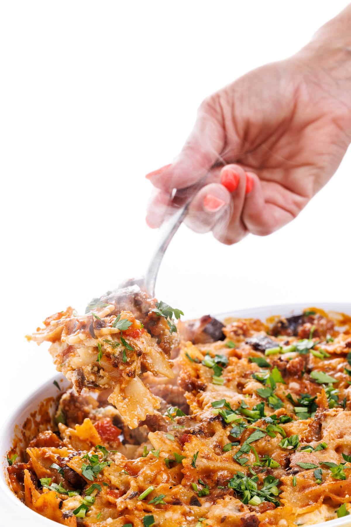 A forkful of sausage and eggplant baked pasta out of the dish.