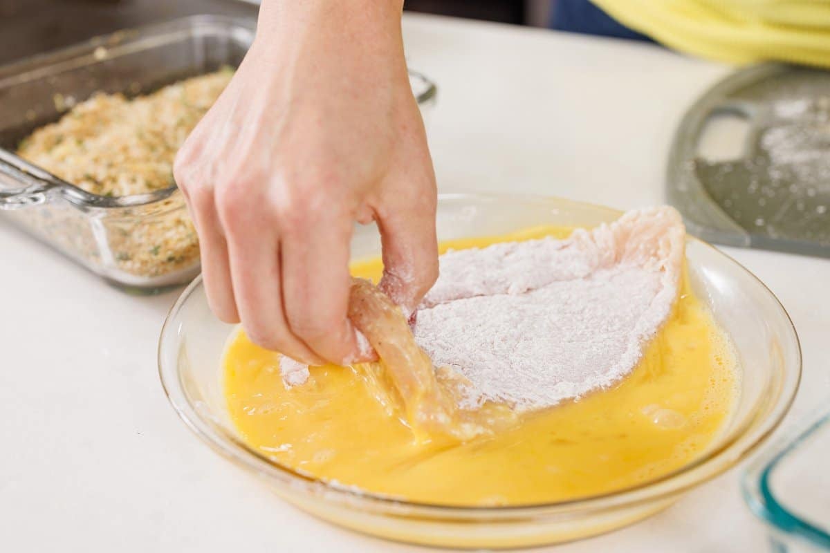 Dipping flour dipped chicken in egg wash,