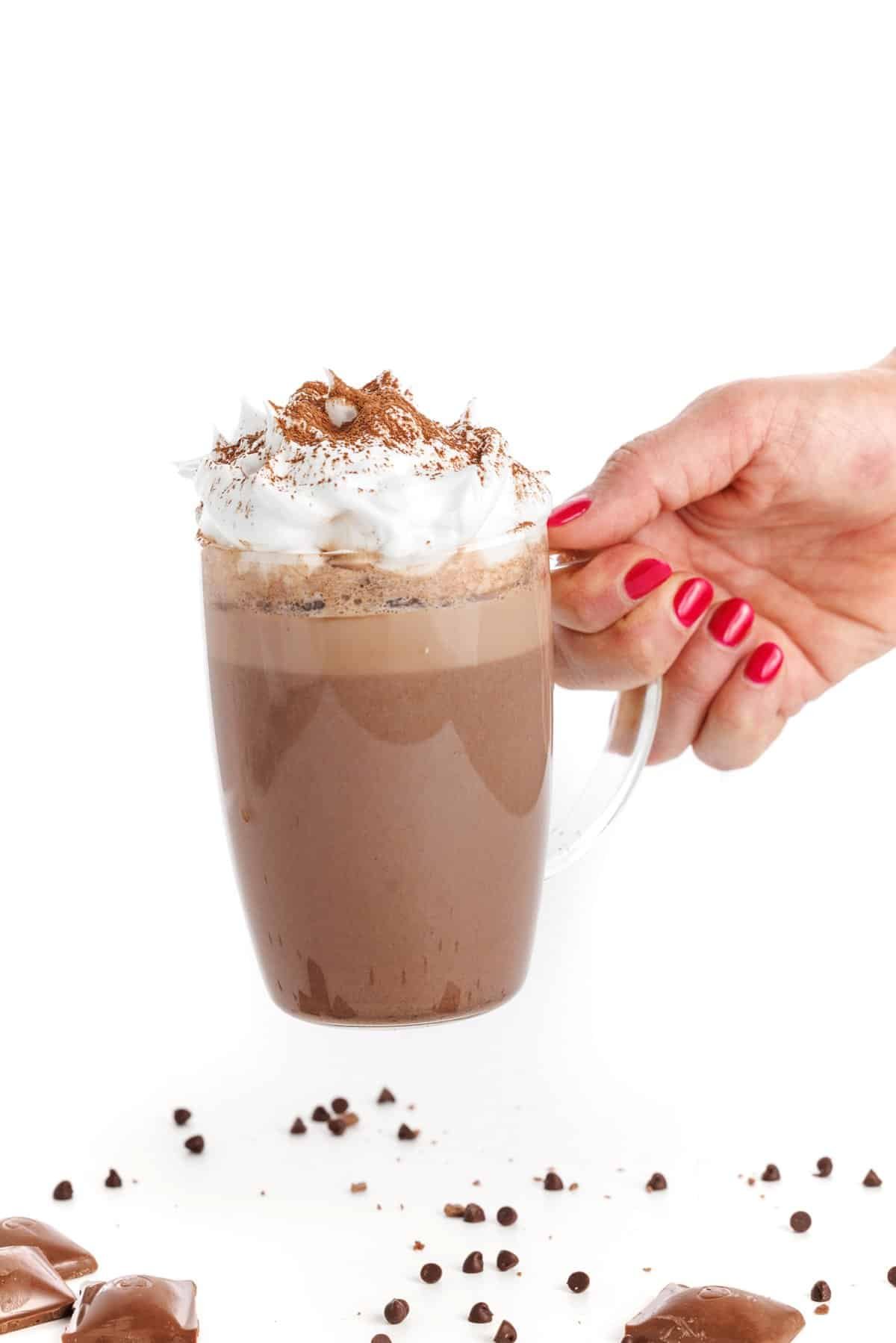 Holding a mug of dark chocolate hot cocoa.