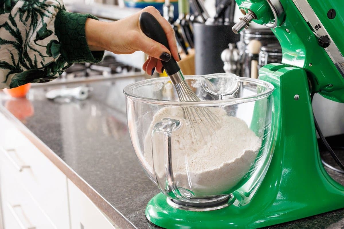 Whisking flour with spices in a glass mixing bowl.