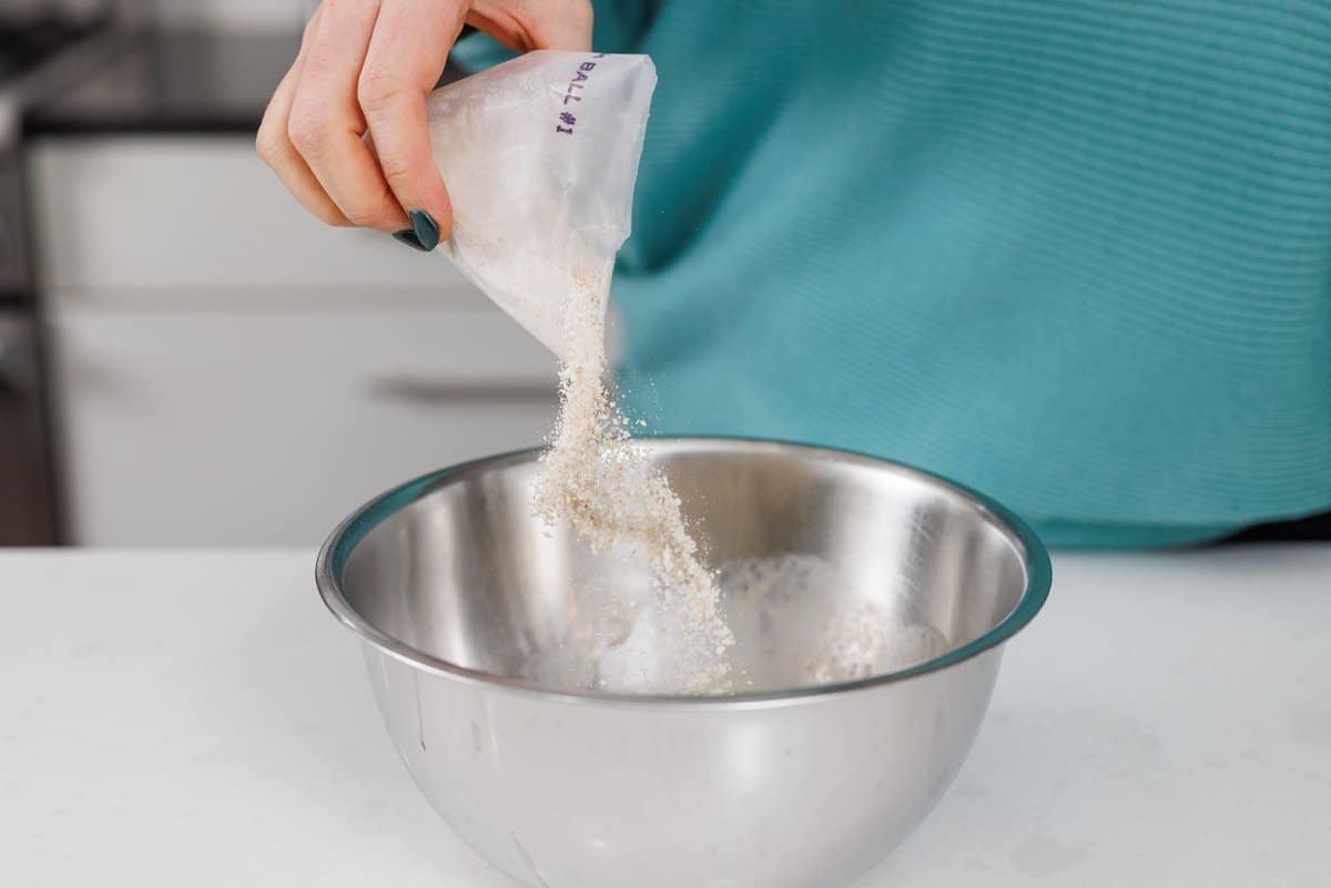 Adding matzo ball mix to bowl.