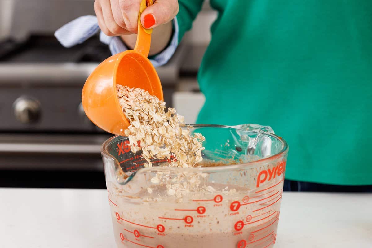 Adding old fashioned oats to chocolatey milk mixture.