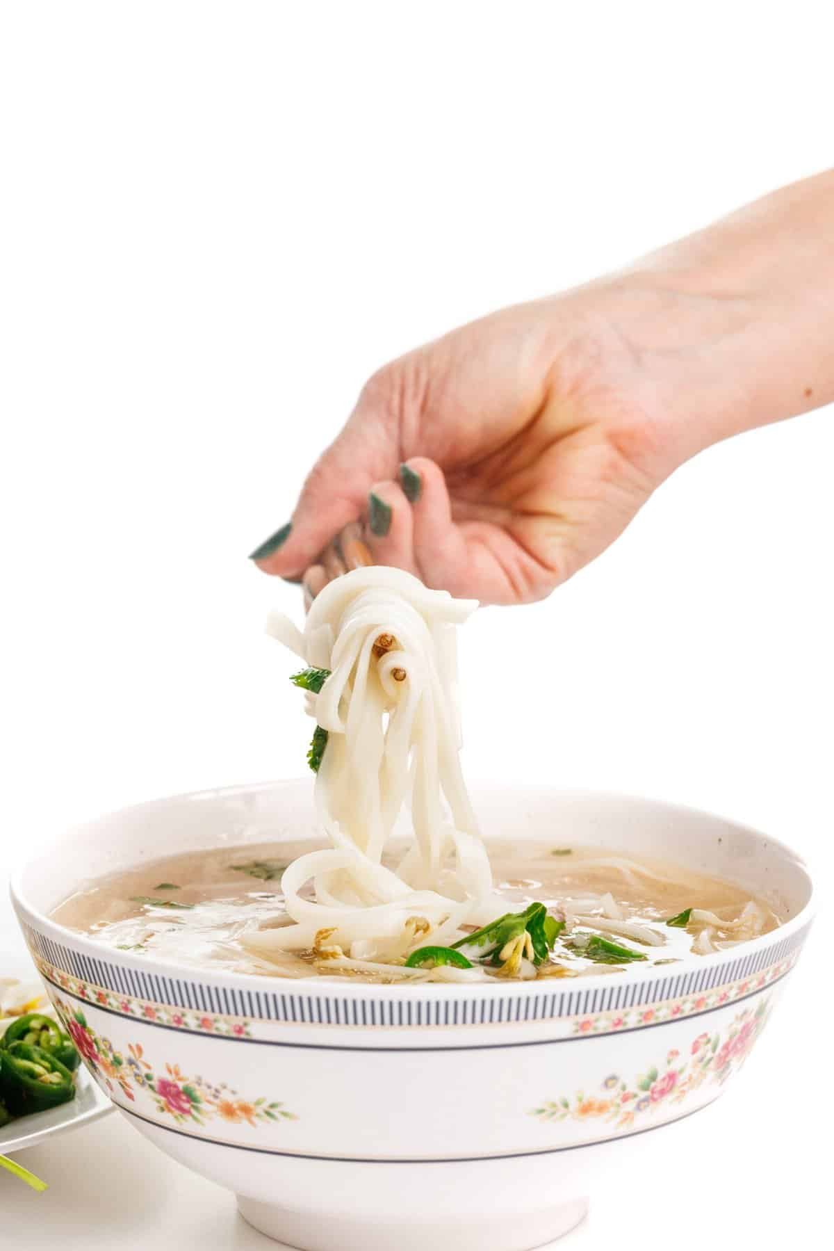 Picking up noodles in beef pho bone broth.