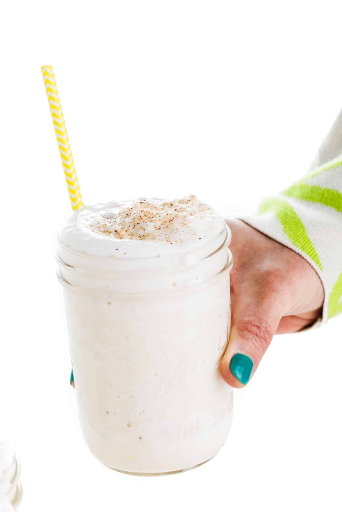 Holding a banana licuado smoothie.