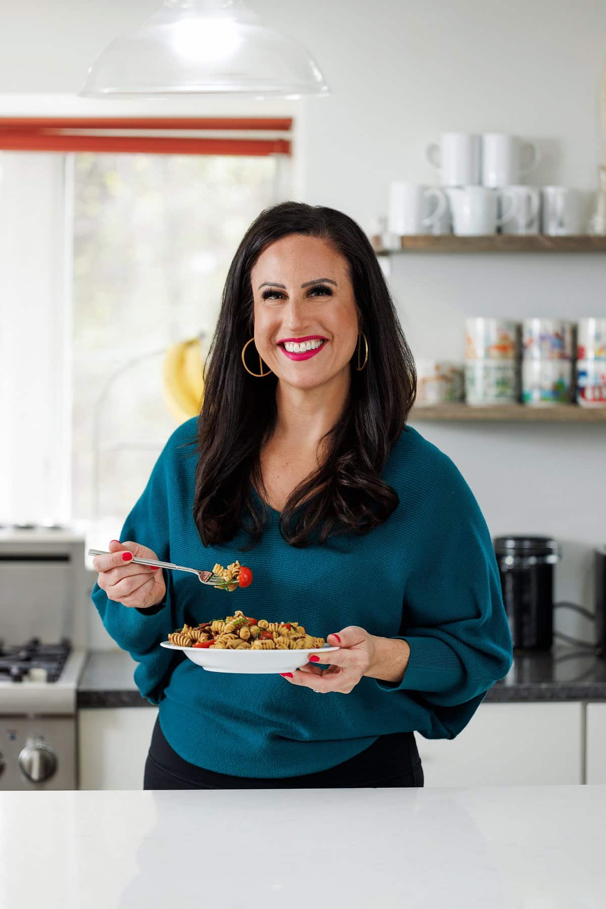 Liz eating pasta salad with pine nuts.