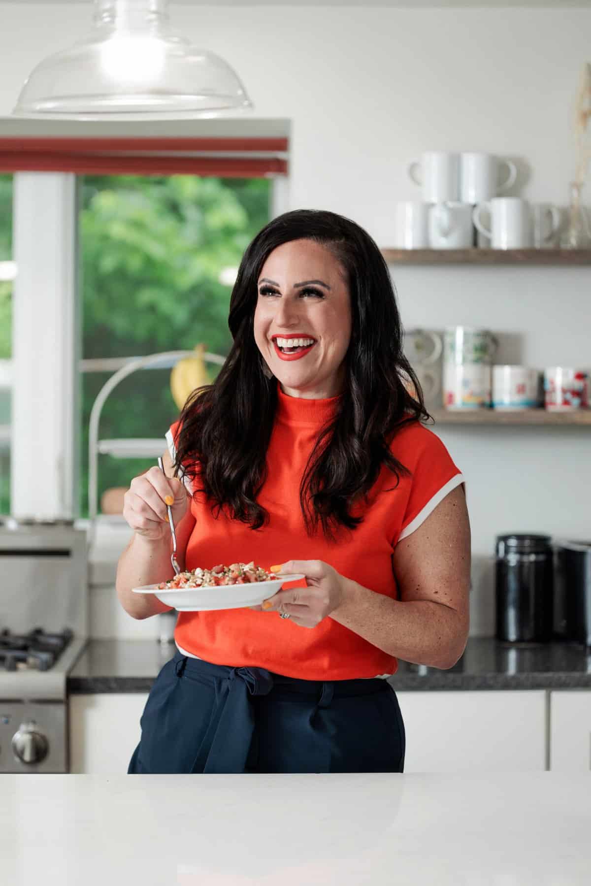 Liz eating a farro Greek salad with dill and feta cheese.
