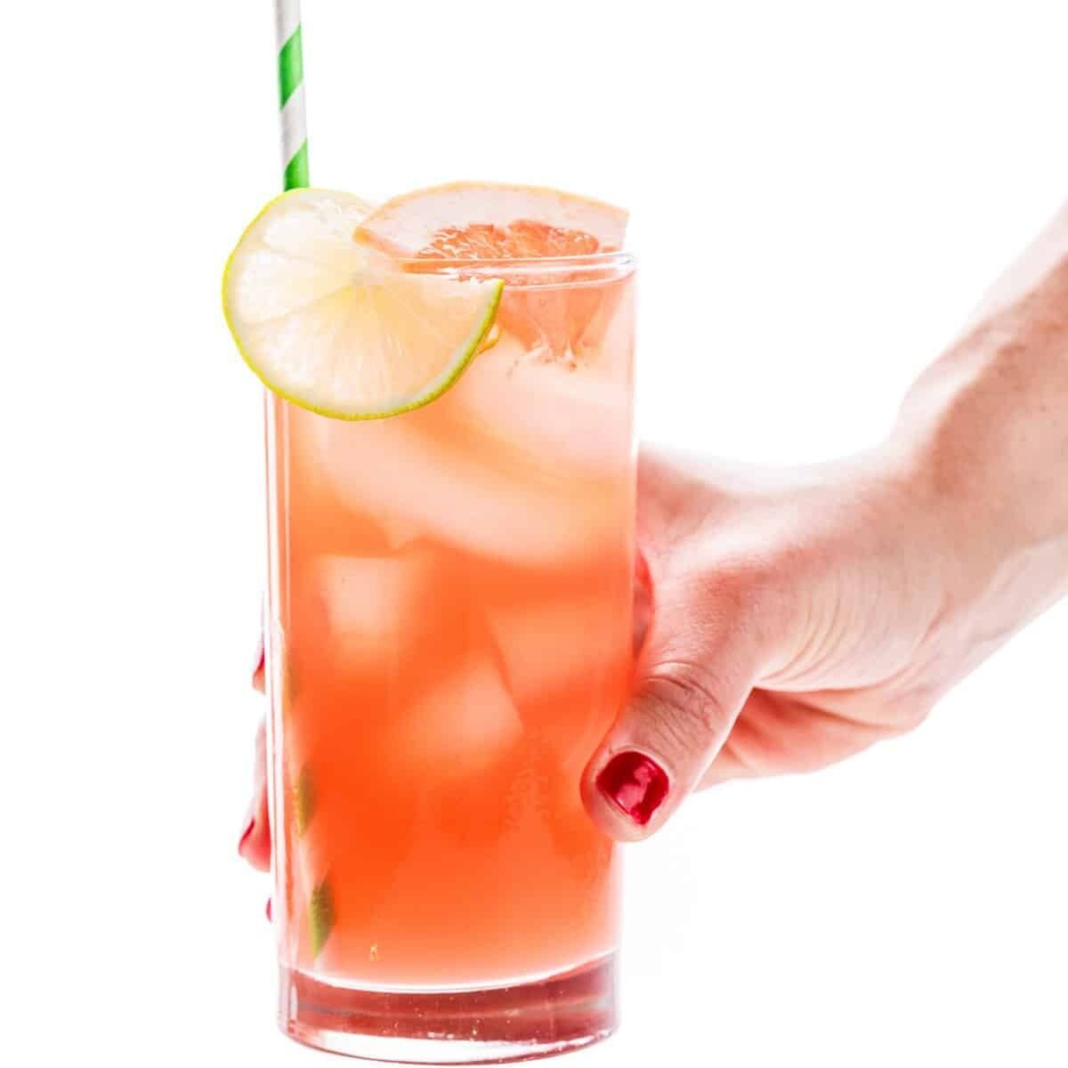 a hand holding a glass of liquid