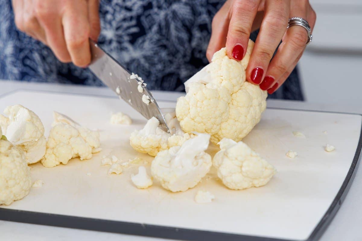 Liz cutting cauliflower into smaller pieces.