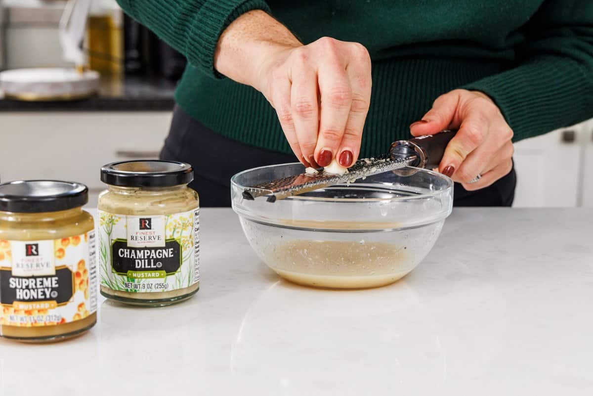 Using a microplane to grate a garlic clove.