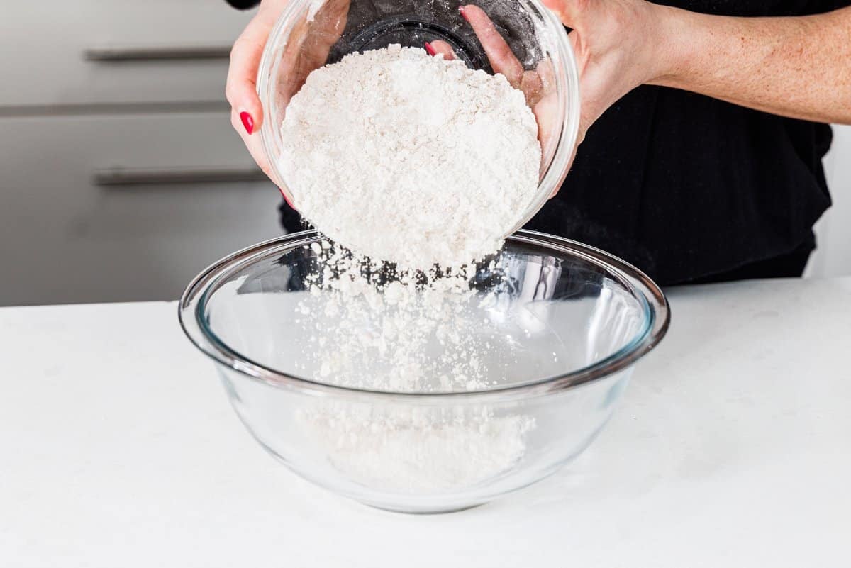 Adding flour to large glass bowl.