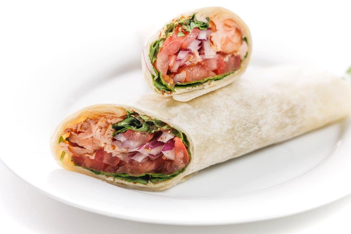 Smoked salmon wrap on a white plate.