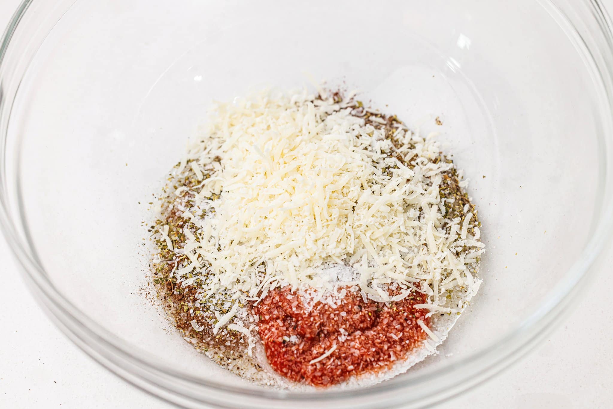 Parmesan and spices in a large glass bowl.