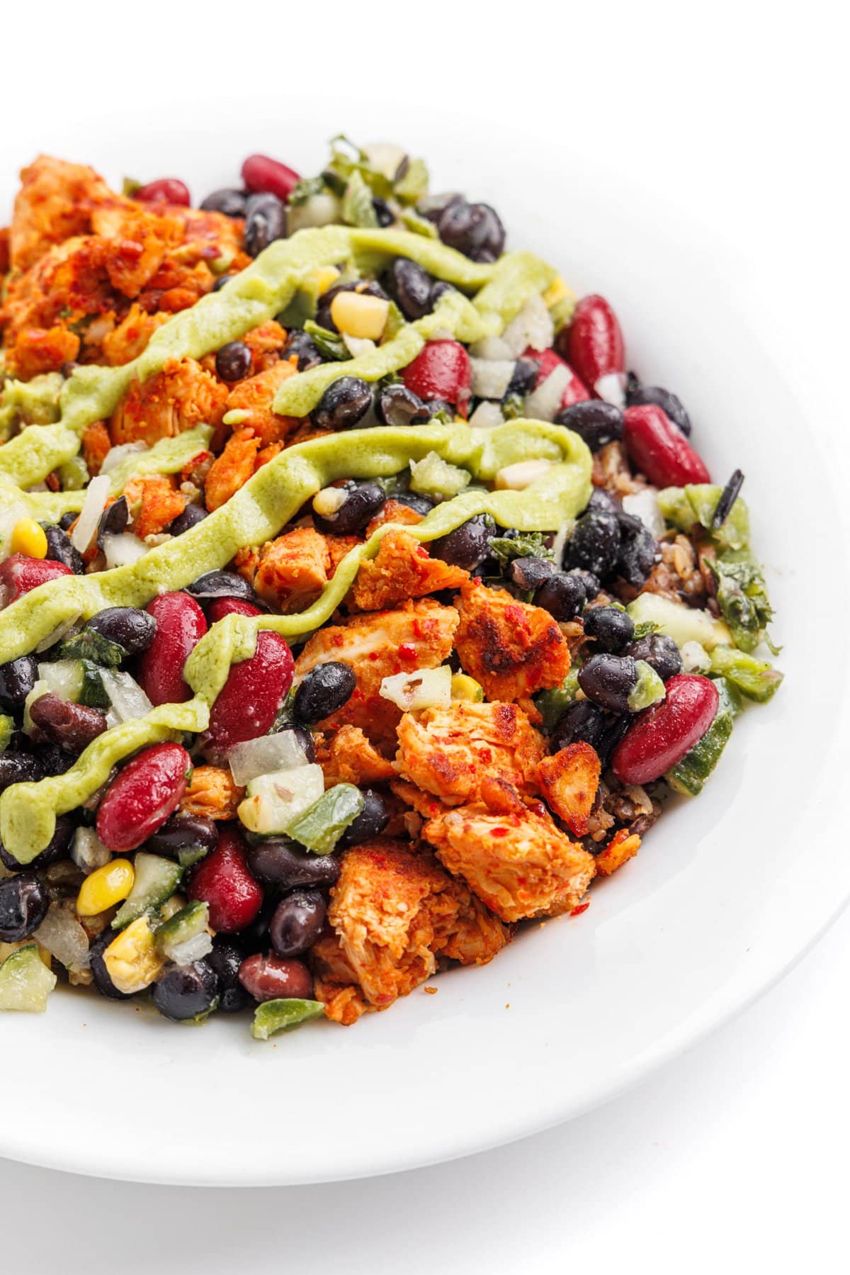 Protein-packed chicken avocado rice bowl drizzled with avocado dressing.