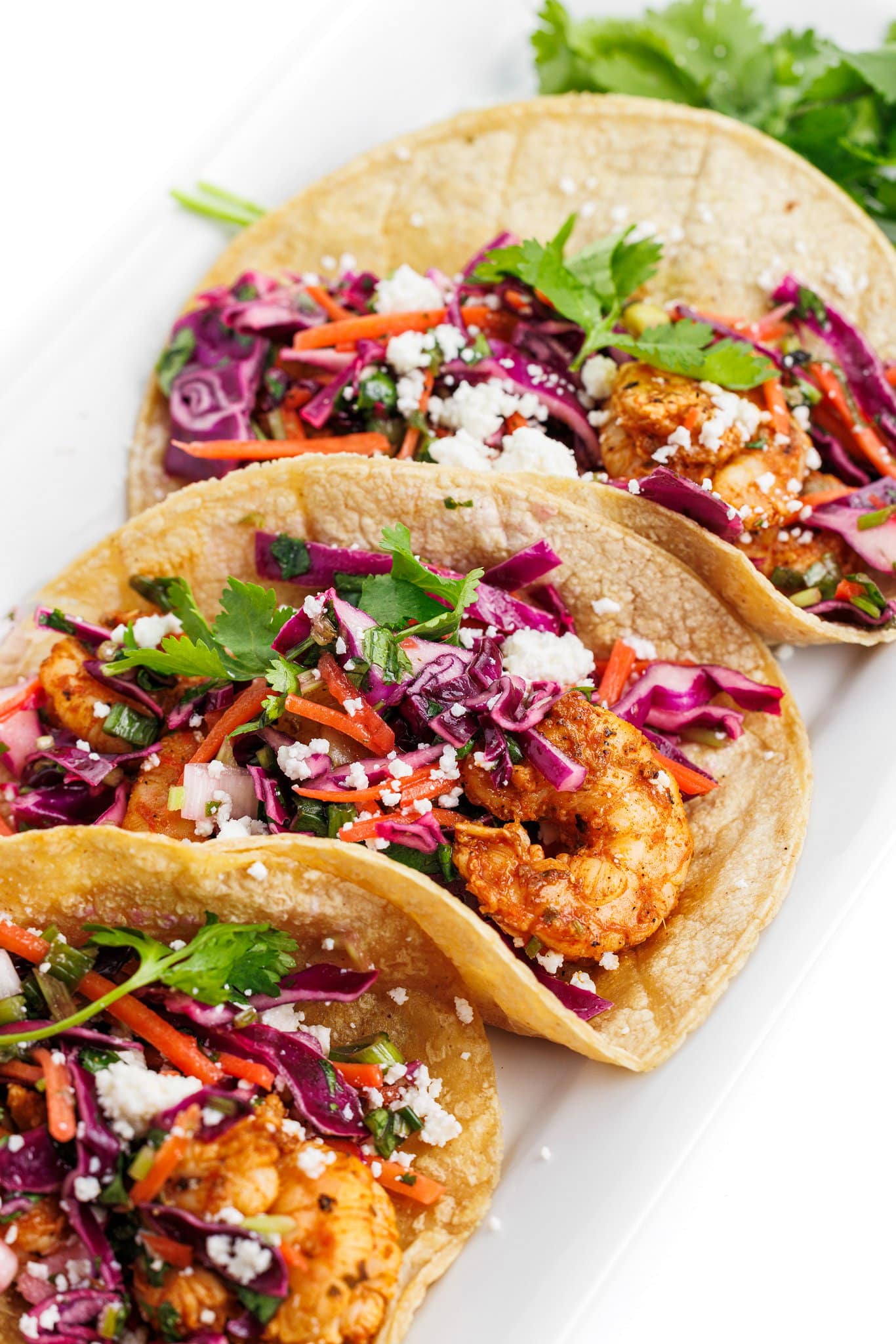 Grilled shrimp tacos with cabbage slaw and topped with cilantro and cotija cheese.
