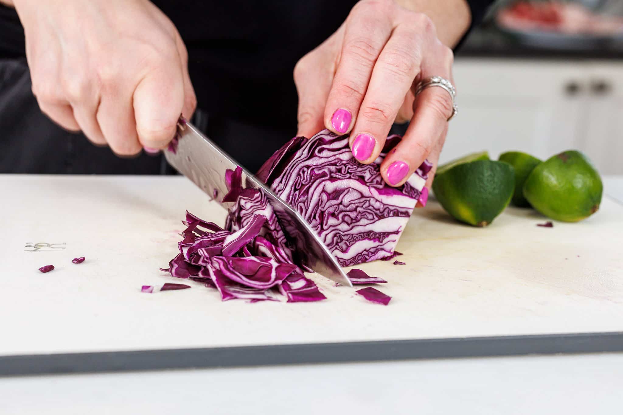 Liz cutting purple cabbage into very thin pieces.