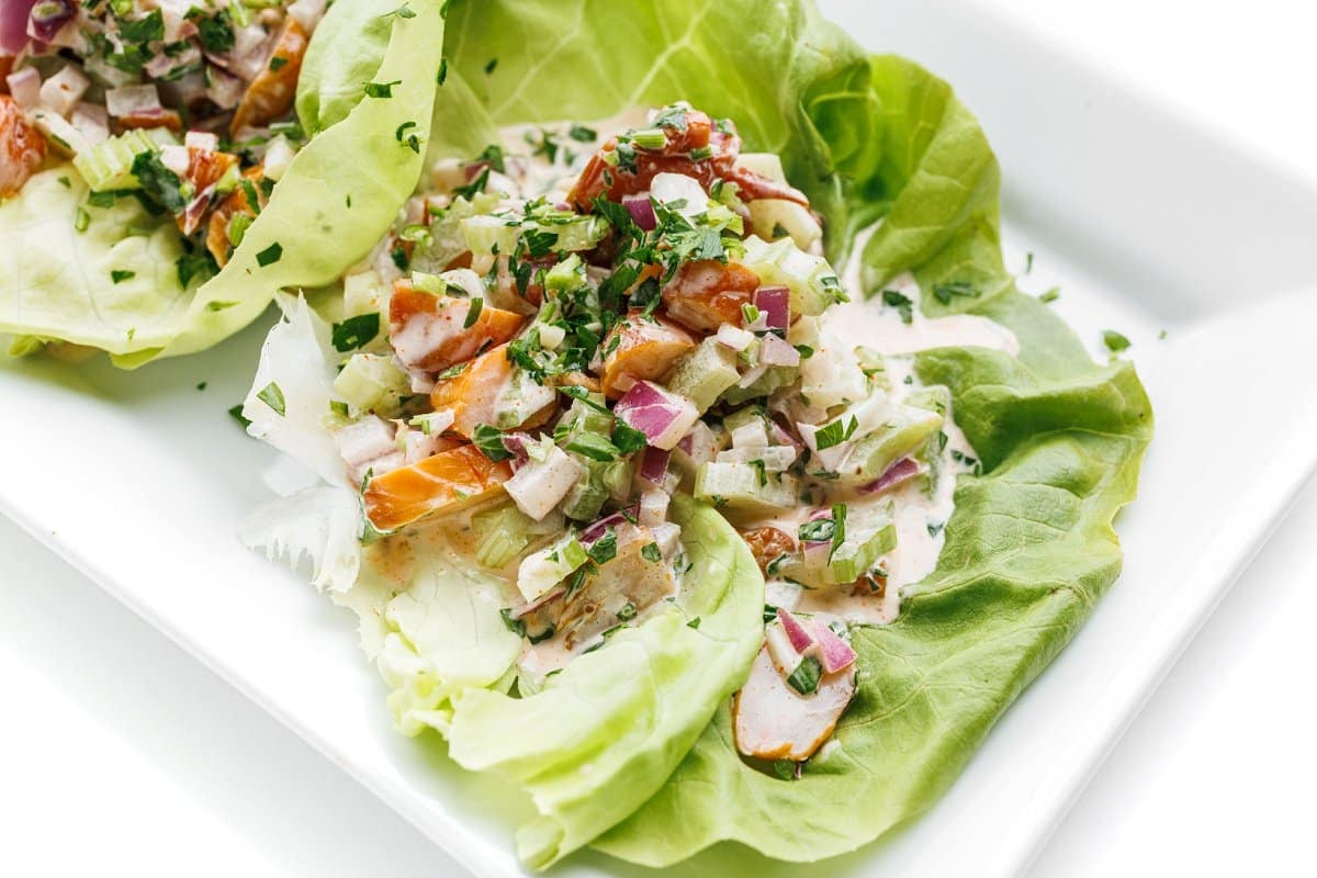 Close up shot of one shrimp salad lettuce cup, topped with fresh parsley.