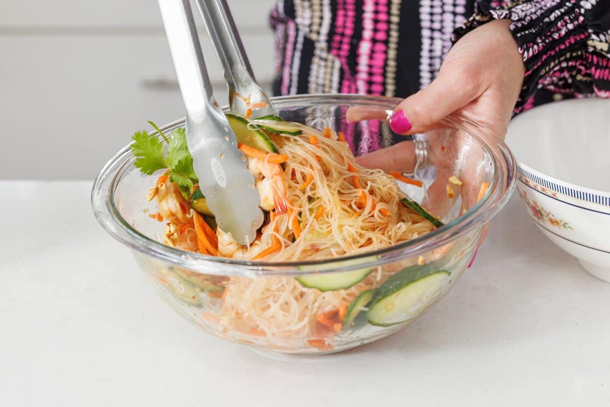 Tossing shrimp bowl ingredients together in a large bowl.
