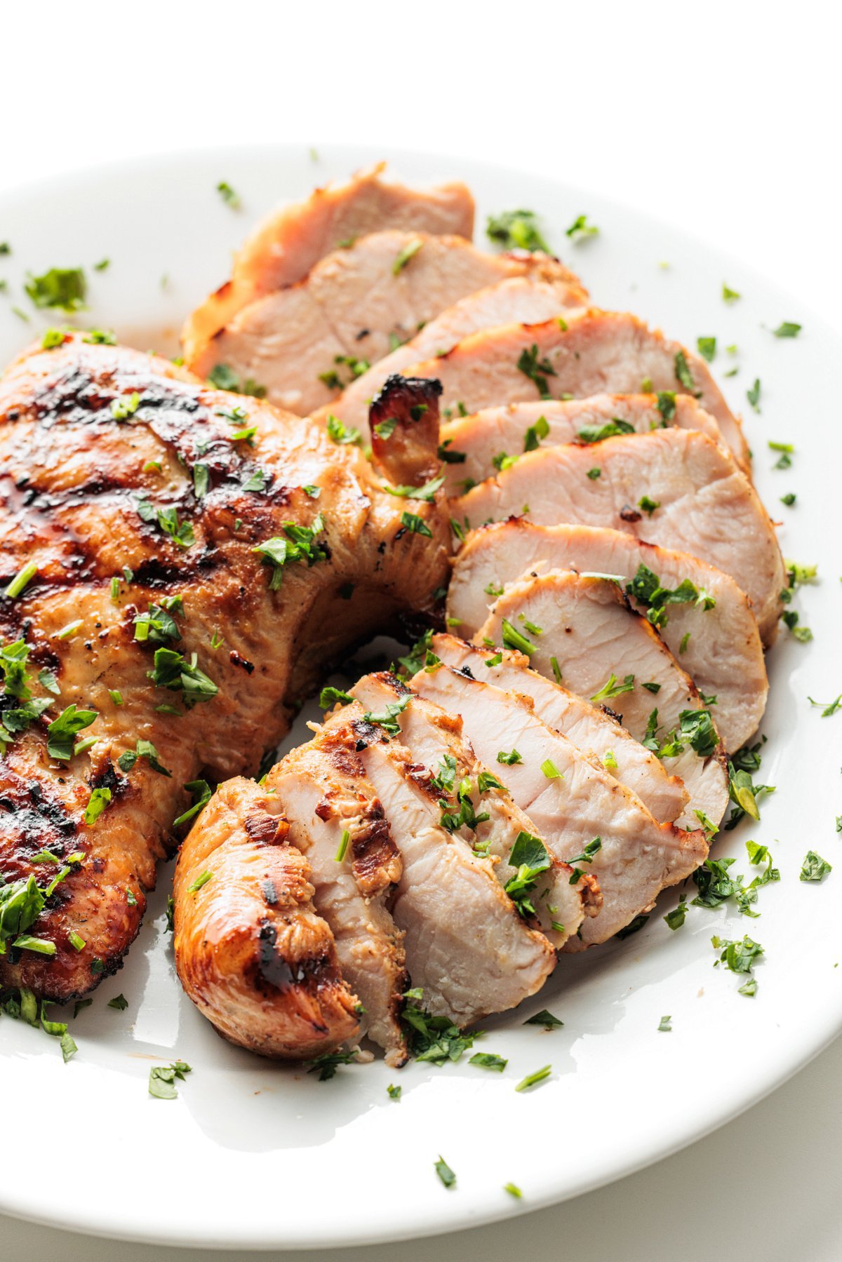 Grilled teriyaki turkey tenderloins garnished with fresh parsley.